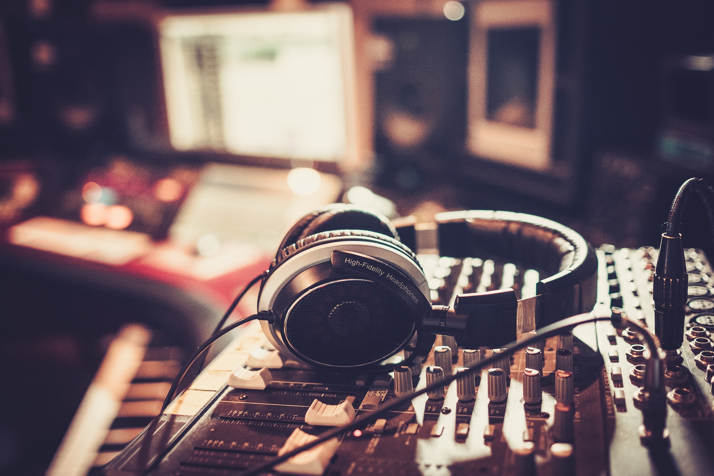 Dettaglio di cuffie audio sopra ad un mixer audio